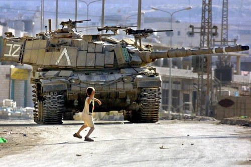 palestinian-child-throwing-rock-at-israeli-tank-photo-by-musa-AL-SHAER-e1481141346313.jpg